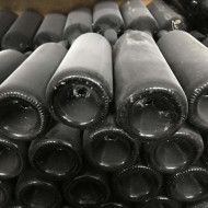 A stack of dusty wine bottles