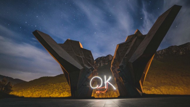Tjentiste spomenik at night with 'OK' written in light as a promo for OK Fest. Photo Credit: Marko Ristic.
