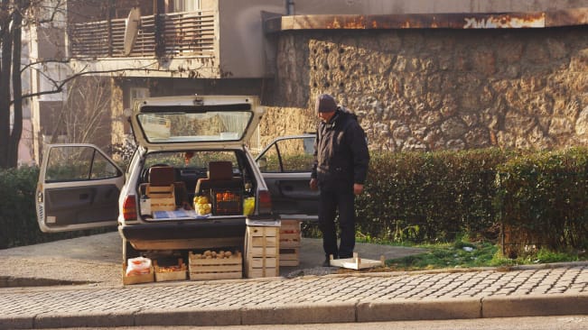 A man selling vegetables from the back of his old VW Golf in Sarajevo
