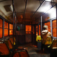 A woman sits alone on the tram at night in Sarajevo.