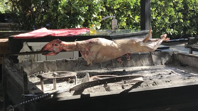 A lamb being spit roasted whole on an outdoor spit in Bosnia