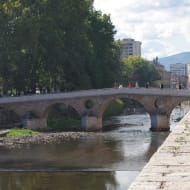 A view of the Latin Bridge in Sarajevo, an old stone pedestrian bridge.