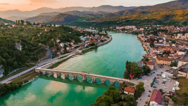 An aerial view of bridge over the Drina river in Višegrad, an old stone, arched bridge