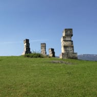 A yugoslav spomenik on a hilltop in Bihac formed of three brutalish concrete totems